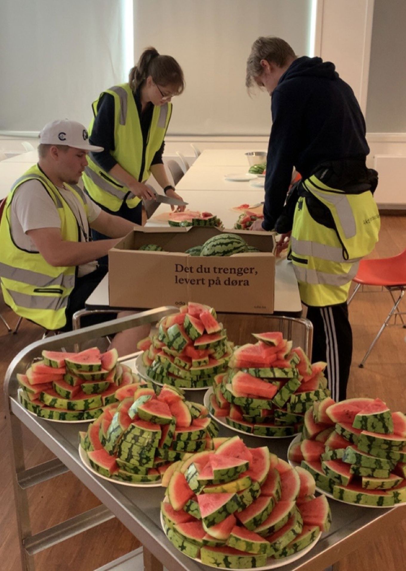 en gruppe mennesker som står rundt et bord med mat på